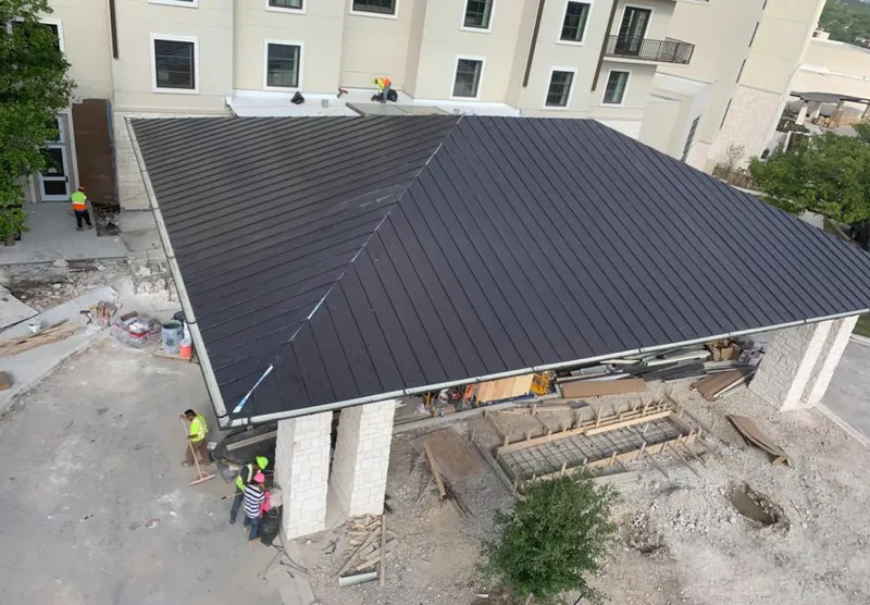Metal roofing installation team working on a commercial building in Jackson